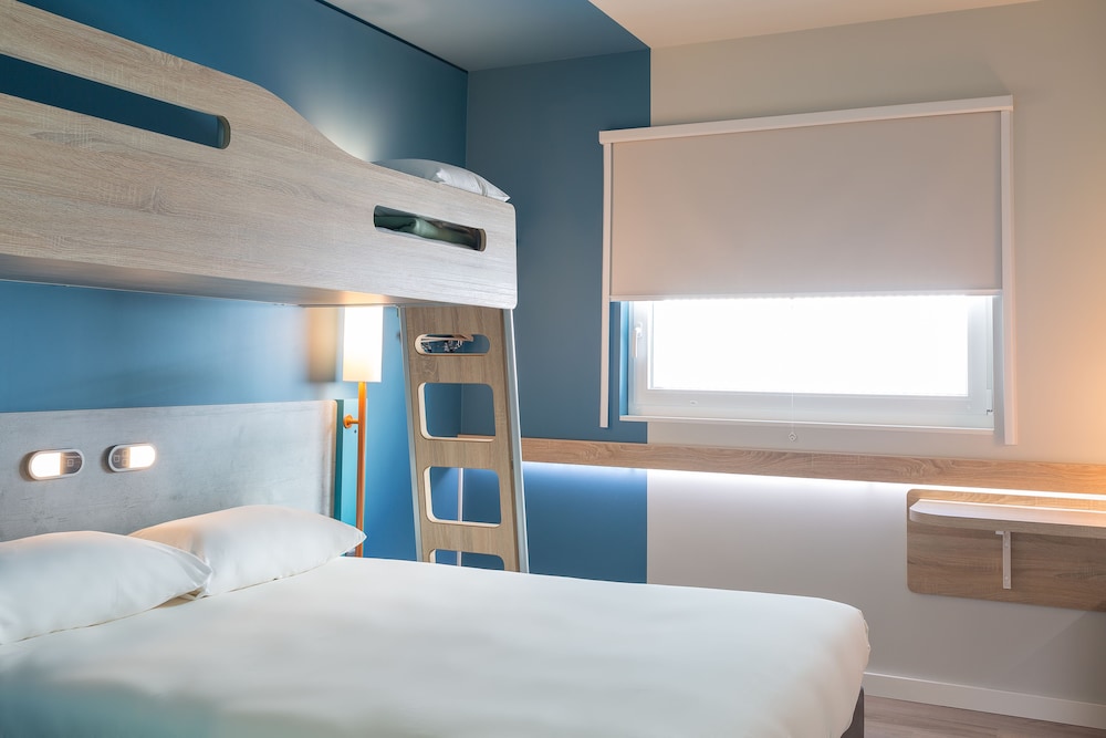 Habitación con una cama de gran tamaño y litera elevada del hotel Ibis Budget Genève Palexpo Aéroport. Foto 1