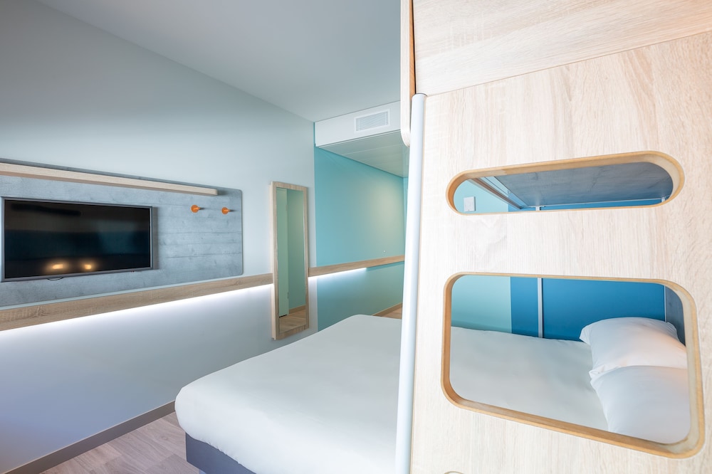 Habitación con una cama de gran tamaño y litera elevada del hotel Ibis Budget Genève Palexpo Aéroport. Foto 2