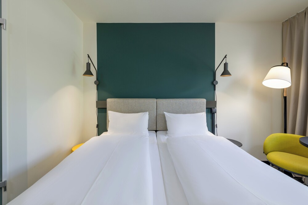 Habitación con 2 camas individuales equipadas con la nueva ropa de cama del hotel Ibis Leipzig City. Foto 1