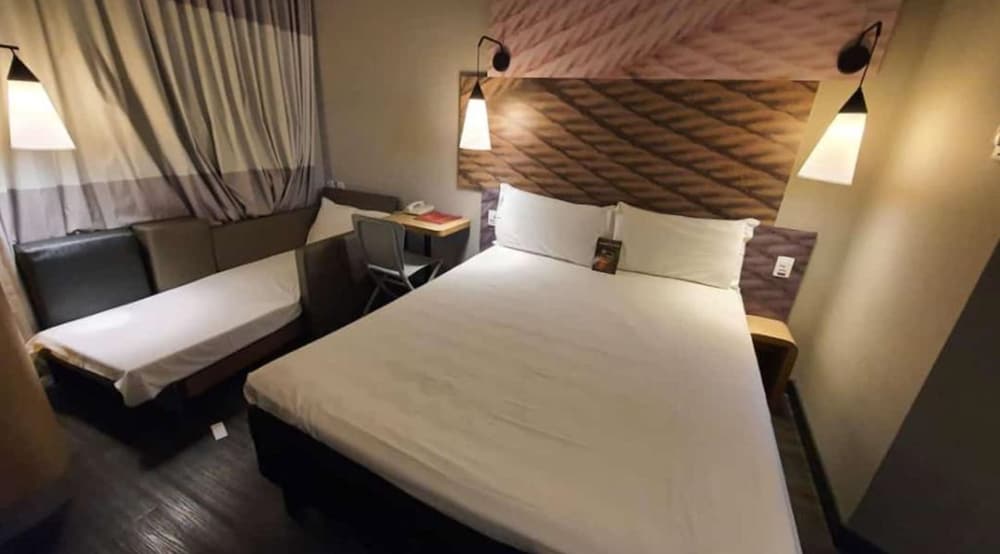 Habitación con una cama doble y una cama supletoria del hotel Ibis Ribeirao Preto Shopping. Foto 9