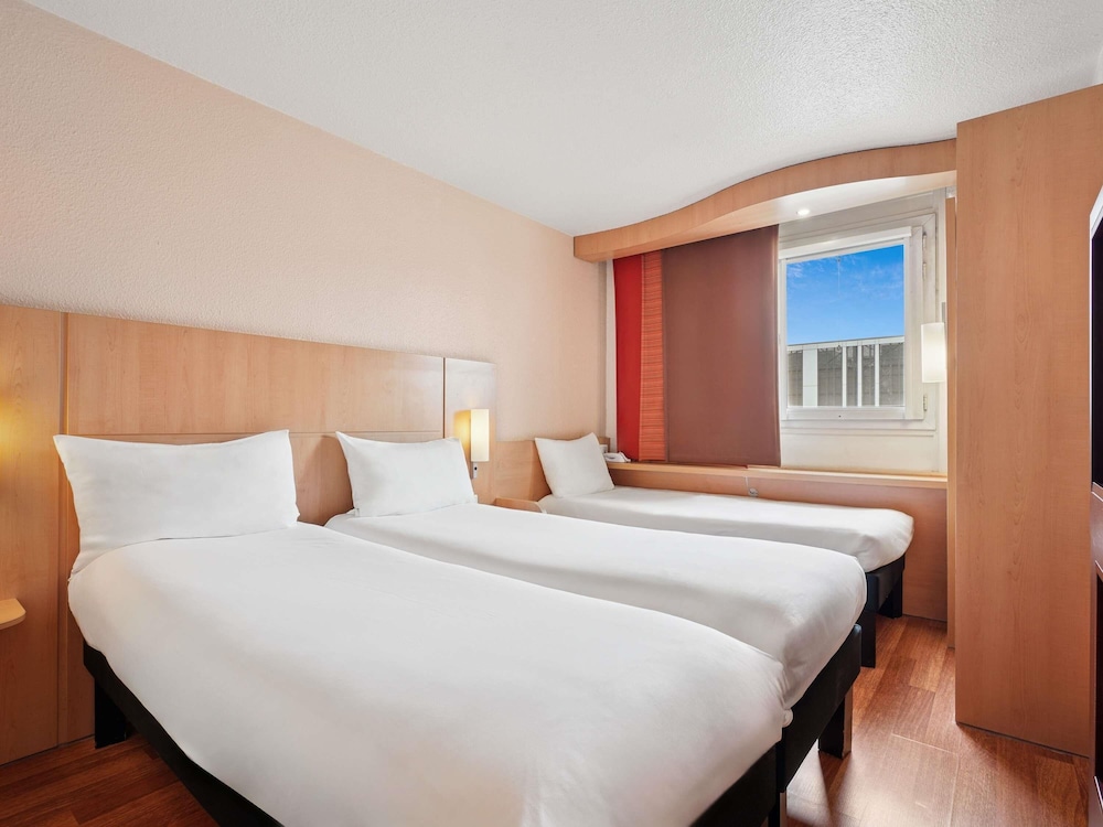 Habitación estándar con camas gemelas y sofá cama del hotel Ibis Paris Porte D'orléans. Foto 3