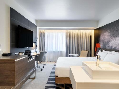 Suite con cama extragrande y sofá cama del hotel Novotel London Tower Bridge. Foto 10