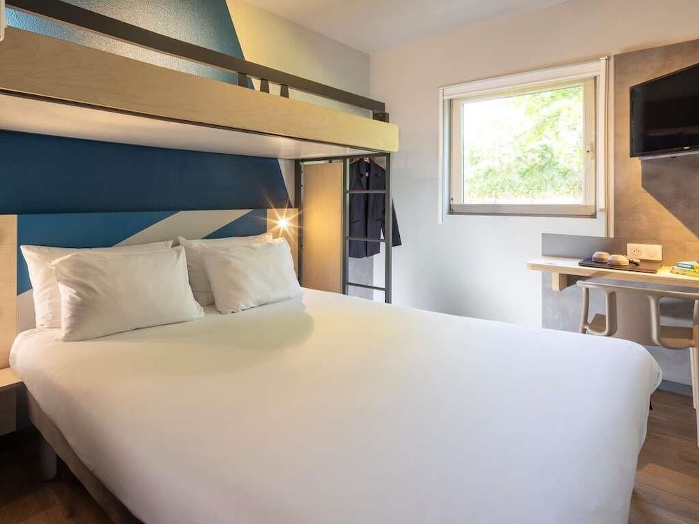 Habitación triple con cama grande y litera superior del hotel Ibis budget Bourg en Bresse. Foto 6