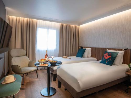 Habitación con 2 camas individuales y diván del hotel Novotel Nice Arenas Aeroport. Foto 2