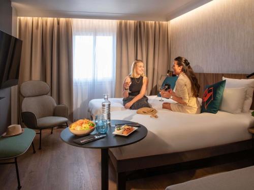 Habitación con 2 camas individuales y diván del hotel Novotel Nice Arenas Aeroport. Foto 3