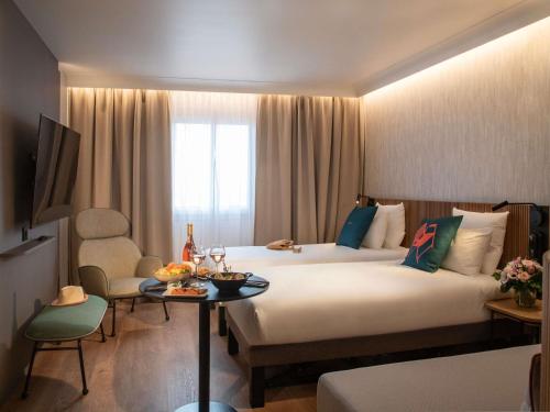 Habitación con 2 camas individuales y diván del hotel Novotel Nice Arenas Aeroport. Foto 4