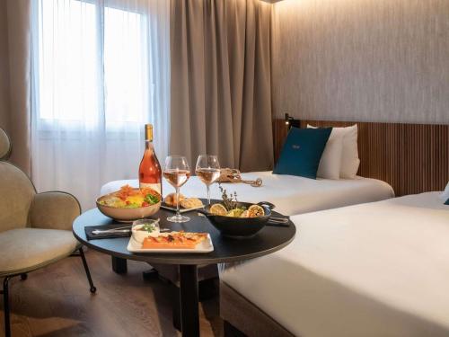 Habitación con 2 camas individuales y diván del hotel Novotel Nice Arenas Aeroport. Foto 5