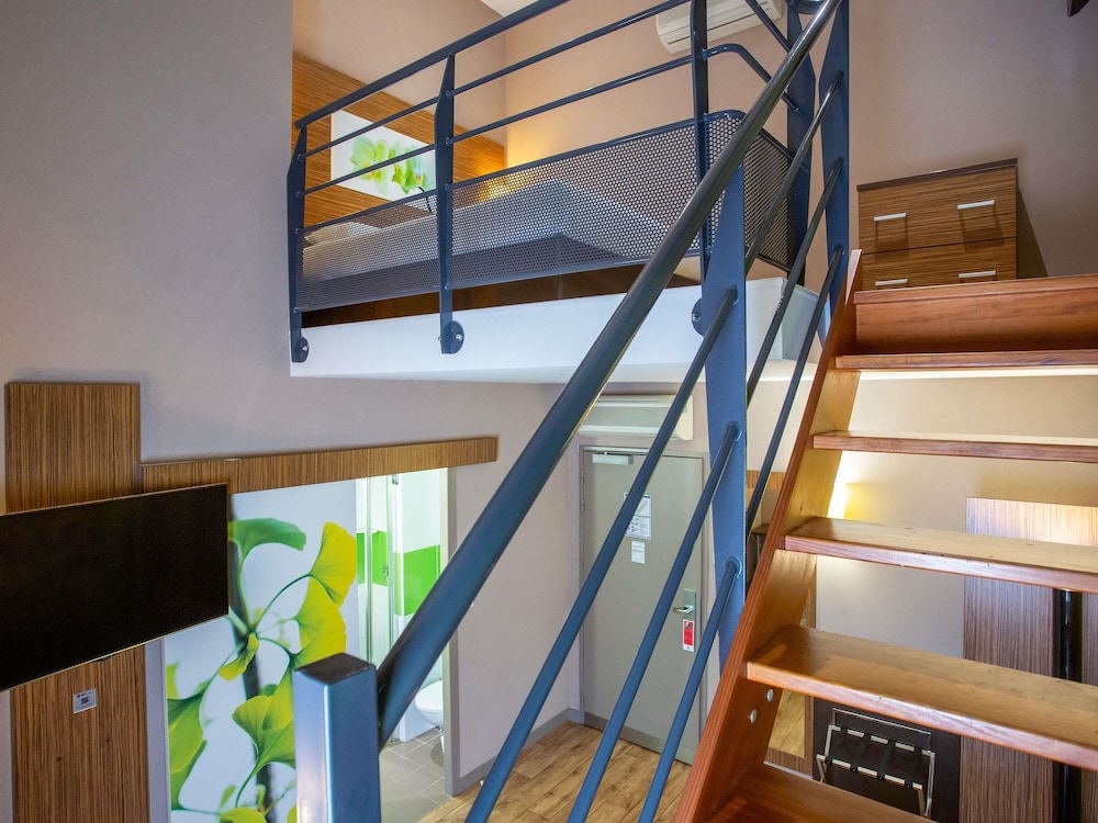 Habitación Privilege con una cama doble y un sofá del hotel Ibis Styles Bourges. Foto 6