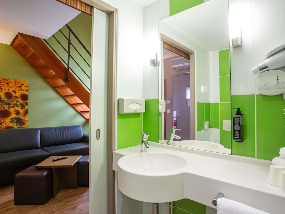 Habitación Privilege con una cama doble y un sofá del hotel Ibis Styles Bourges. Foto 7