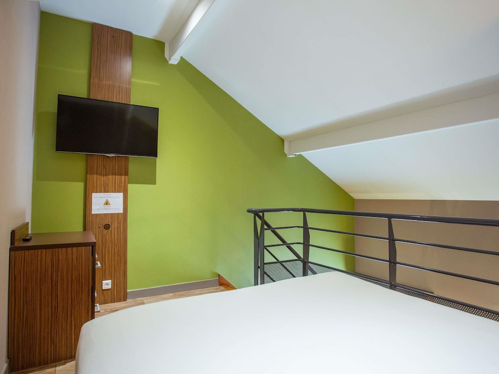Habitación Privilege con una cama doble y un sofá del hotel Ibis Styles Bourges. Foto 13