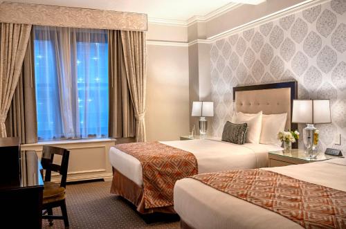 Suite Premier de 1 dormitorio con 2 camas dobles y vistas a la ciudad del hotel THE WARWICK NEW YORK HOTEL