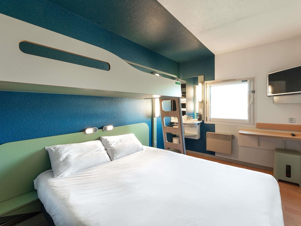 Habitación TRIPLE con una cama de gran tamaño y litera del hotel Ibis Budget Mâcon Nord. Foto 4