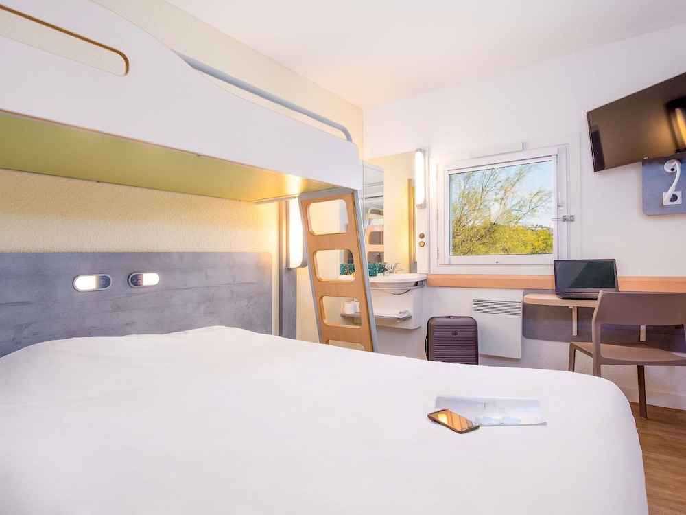 Habitación triple con una cama de gran tamaño y una cama en litera del hotel Ibis Budget Fréjus Saint-raphaël Capitou A8. Foto 1