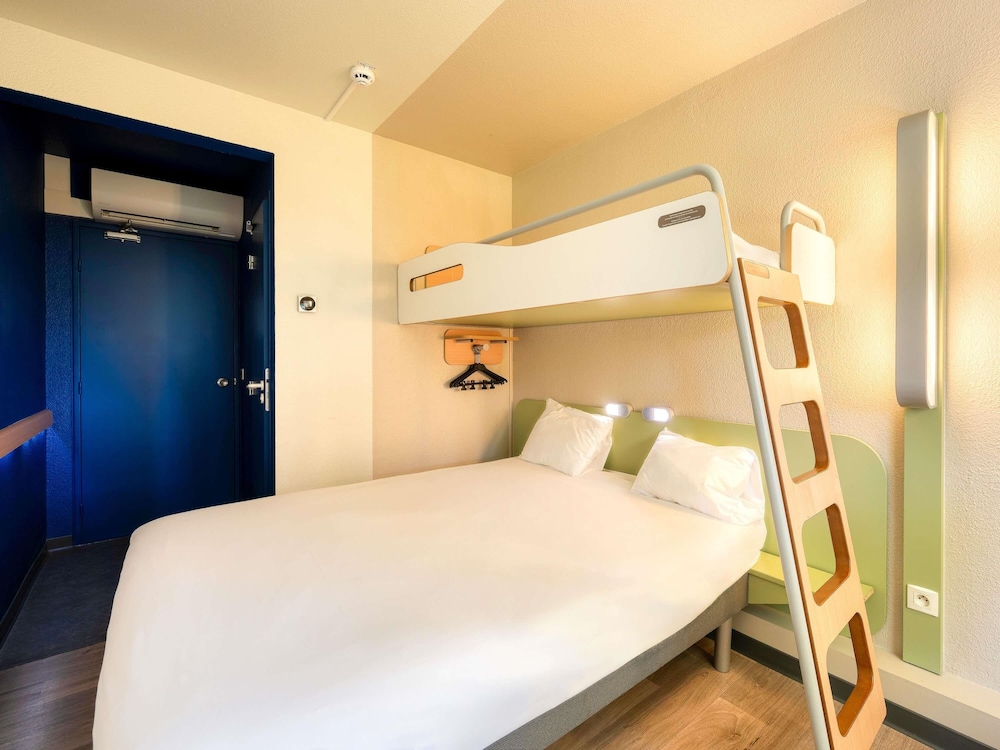 TRIPLE - Habitación con una cama grande y una cama litera del hotel Ibis Budget Versailles - Trappes. Foto 1