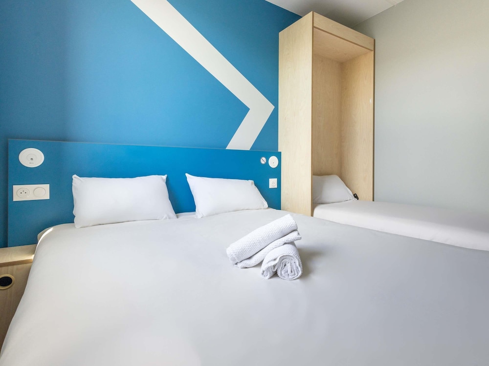 Habitación con una cama grande y una litera del hotel Ibis Budget Nanterre La Defense