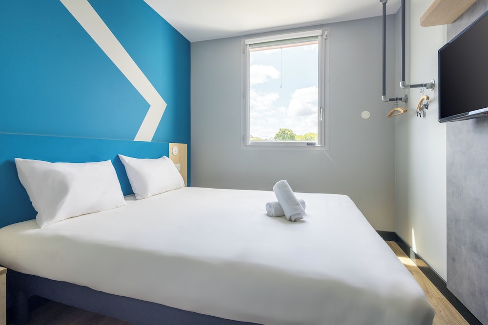 Habitación con una cama grande y una litera del hotel Ibis Budget Nanterre La Defense. Foto 1