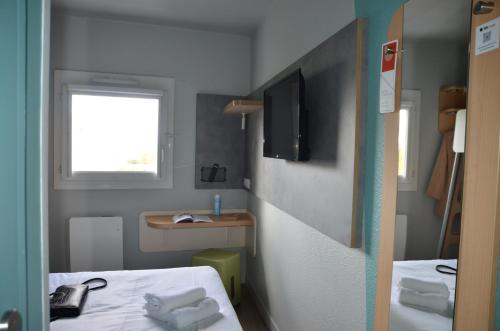 Habitación doble con una cama grande del hotel Ibis Budget Rouen Nord Isneauville. Foto 1