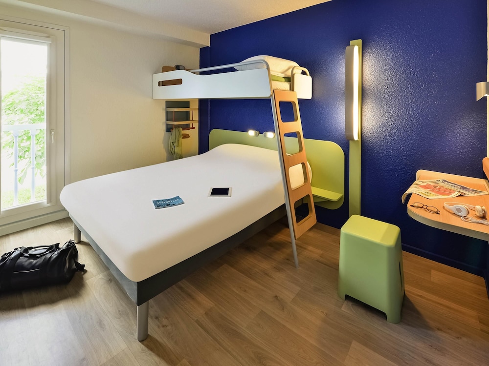 Habitación triple con una cama de gran tamaño y una cama en litera del hotel Ibis Budget Chambéry Centre Ville