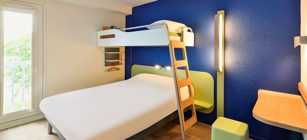 Habitación triple con una cama de gran tamaño y una cama en litera del hotel Ibis Budget Chambéry Centre Ville. Foto 1