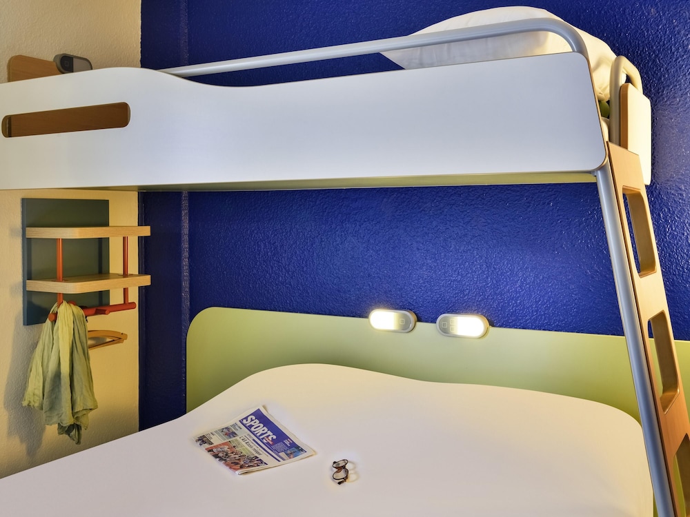 Habitación triple con una cama de gran tamaño y una cama en litera del hotel Ibis Budget Chambéry Centre Ville. Foto 3