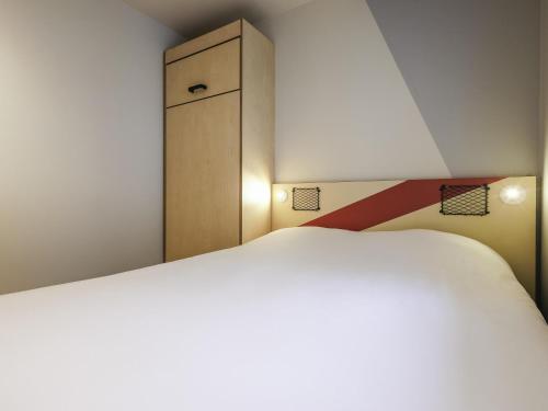 DORMITORIO - con una cama grande y un armario del hotel Ibis Budget Villemomble. Foto 3