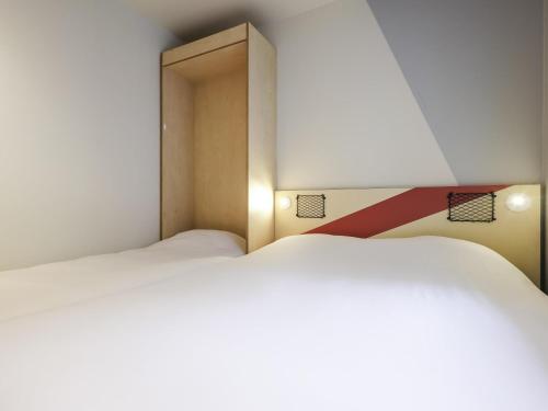 DORMITORIO - con una cama grande y un armario del hotel Ibis Budget Villemomble. Foto 4