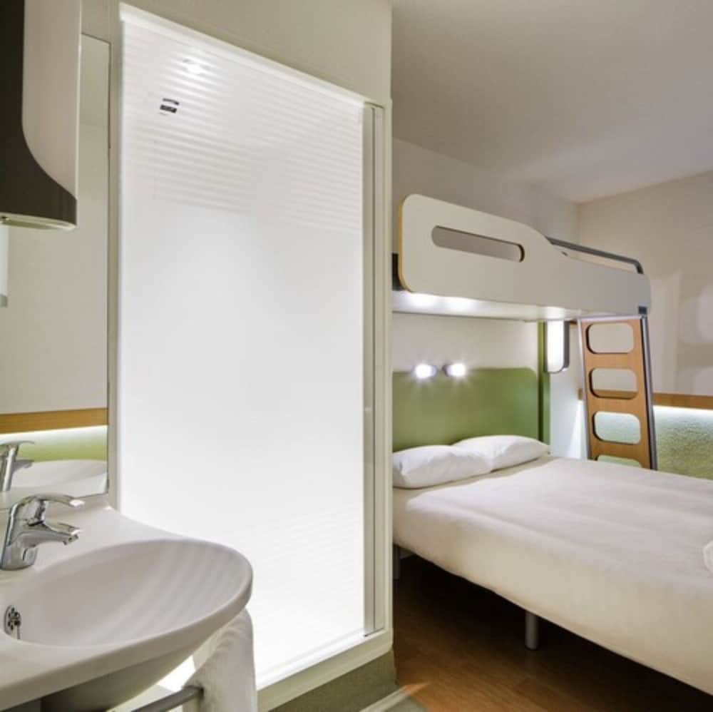 TRIPLE - Habitación con una cama grande y una litera del hotel Ibis Budget Dole. Foto 6
