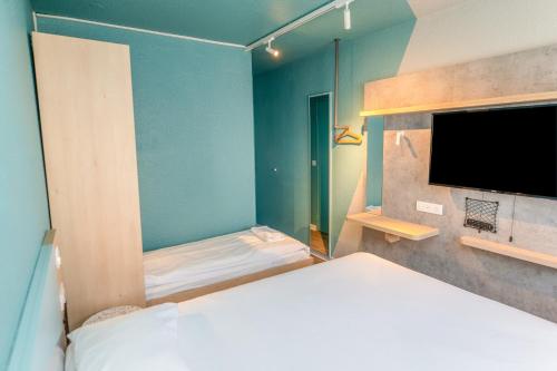 Esta habitación triple cuenta con 1 cama doble y 1 cama individual del hotel Ibis Budget Brest Sud Plougastel. Foto 1