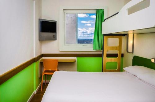 TRIPLE - Habitación con una cama grande y una cama litera del hotel Ibis Budget Brignoles Provence. Foto 2