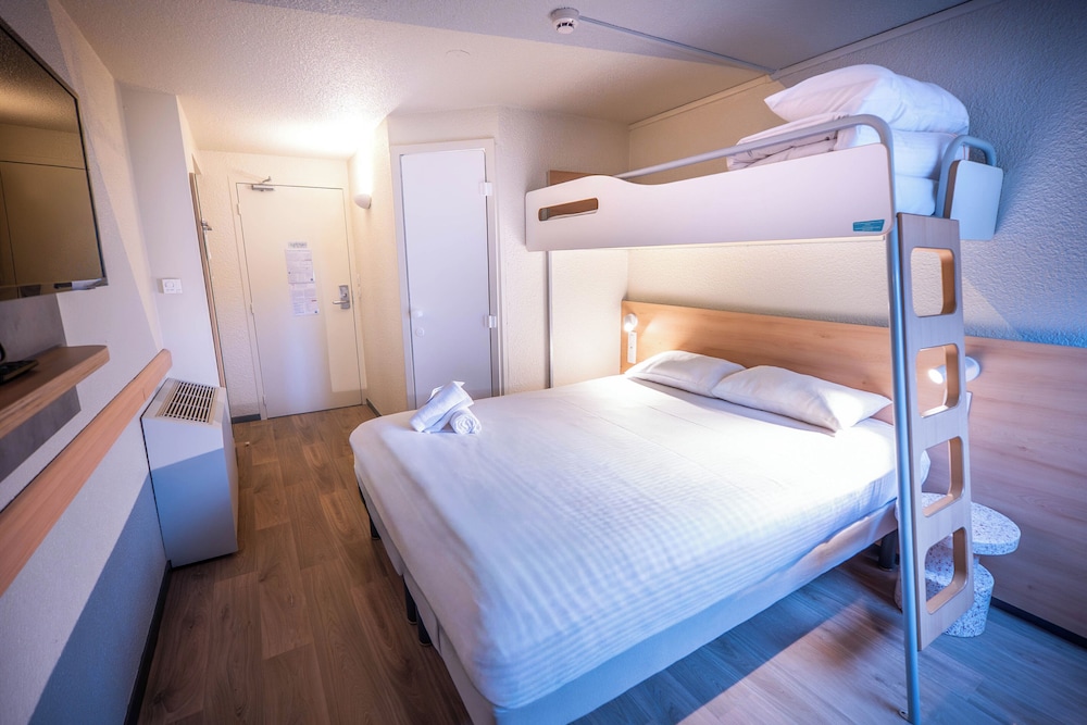 TRIPLE - Habitación con una cama grande y una litera del hotel Ibis Budget Metz Sud Augny. Foto 1