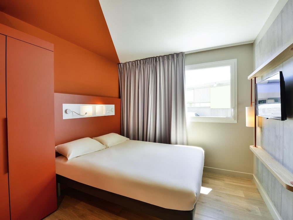 Habitación doble con cama de gran tamaño del hotel Ibis Budget Mâcon Crêches. Foto 1