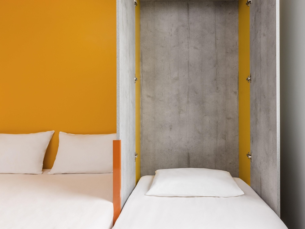 HABITACIÓN TRIPLE. Habitación triple con una cama de gran tamaño y una cama plegable del hotel Ibis Budget Mâcon Crêches
