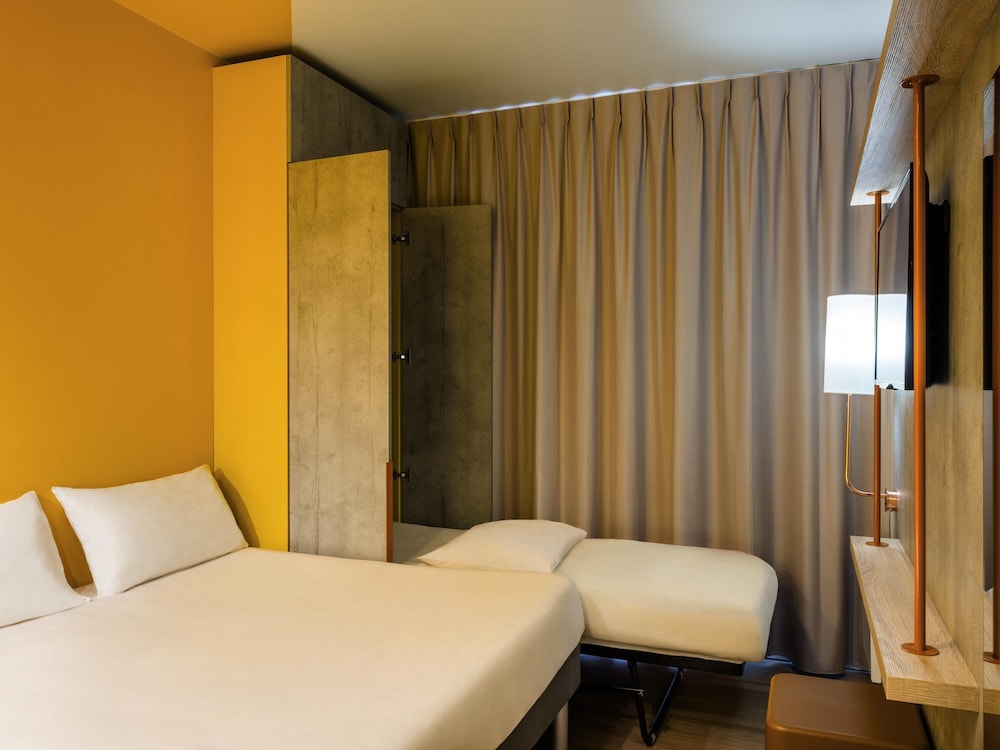HABITACIÓN TRIPLE. Habitación triple con una cama de gran tamaño y una cama plegable del hotel Ibis Budget Mâcon Crêches. Foto 2