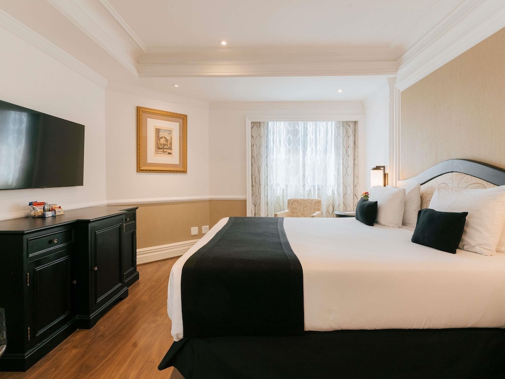 Habitación Deluxe con cama doble y balcón frente al Parque Ibirapuera del hotel Grand Mercure Sao Paulo Ibirapuera