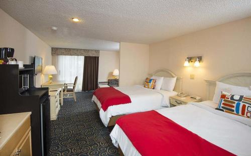 Habitación con 2 camas grandes y ducha a ras de suelo del hotel Tiki Resort - Lake George