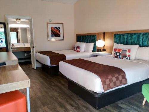 Habitación con 2 camas grandes y ducha a ras de suelo del hotel Tiki Resort - Lake George. Foto 3