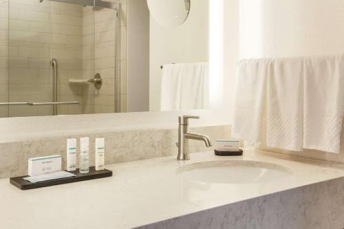Suite adaptada para personas con movilidad reducida con cama grande y ducha a ras de suelo del hotel Embassy Suites By Hilton Syracuse Destiny Usa. Foto 1