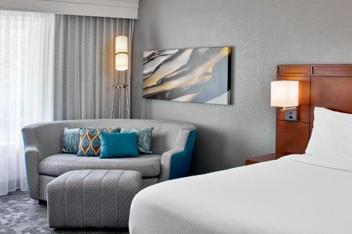 Habitación con sofá cama y bañera adaptada para personas con movilidad reducida - Cama extragrande del hotel Courtyard Rochester East / Penfield