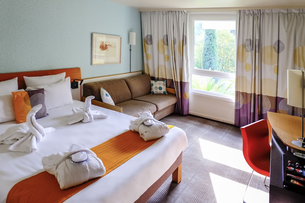 Habitación de categoría superior orientada a la piscina - Una cama doble y sofá cama doble del hotel Novotel Marseille Est Porte D'aubagne. Foto 2