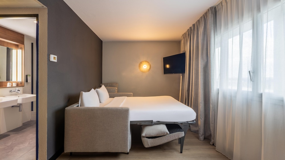 Habitación superior, 1 cama de matrimonio grande con sofá cama del hotel CAMPANILE ROISSY. Foto 2