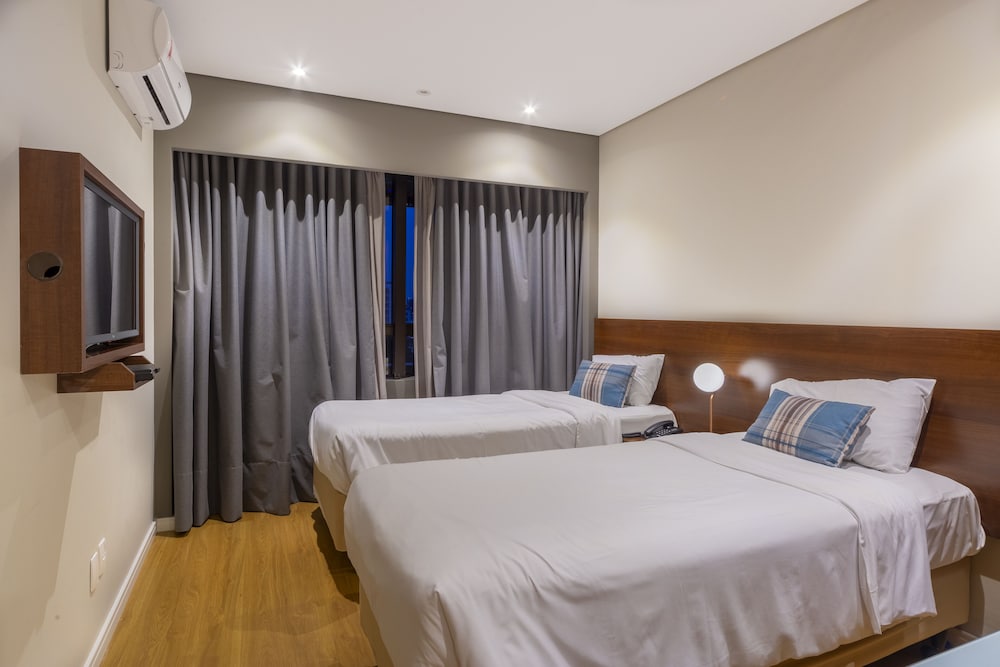 Habitación familiar con 1 cama doble, 2 camas individuales y 1 sofá cama del hotel Mercure Curitiba Golden. Foto 1