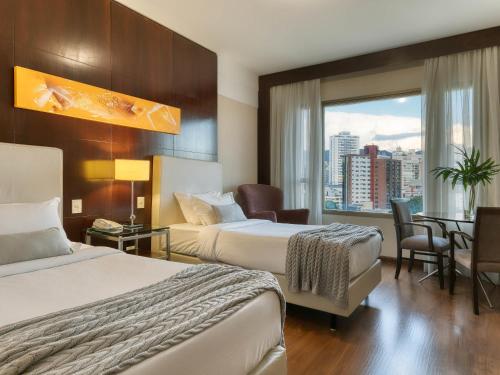 Habitación Clásica con una cama doble y una cama individual del hotel Mercure Belo Horizonte Lourdes. Foto 1