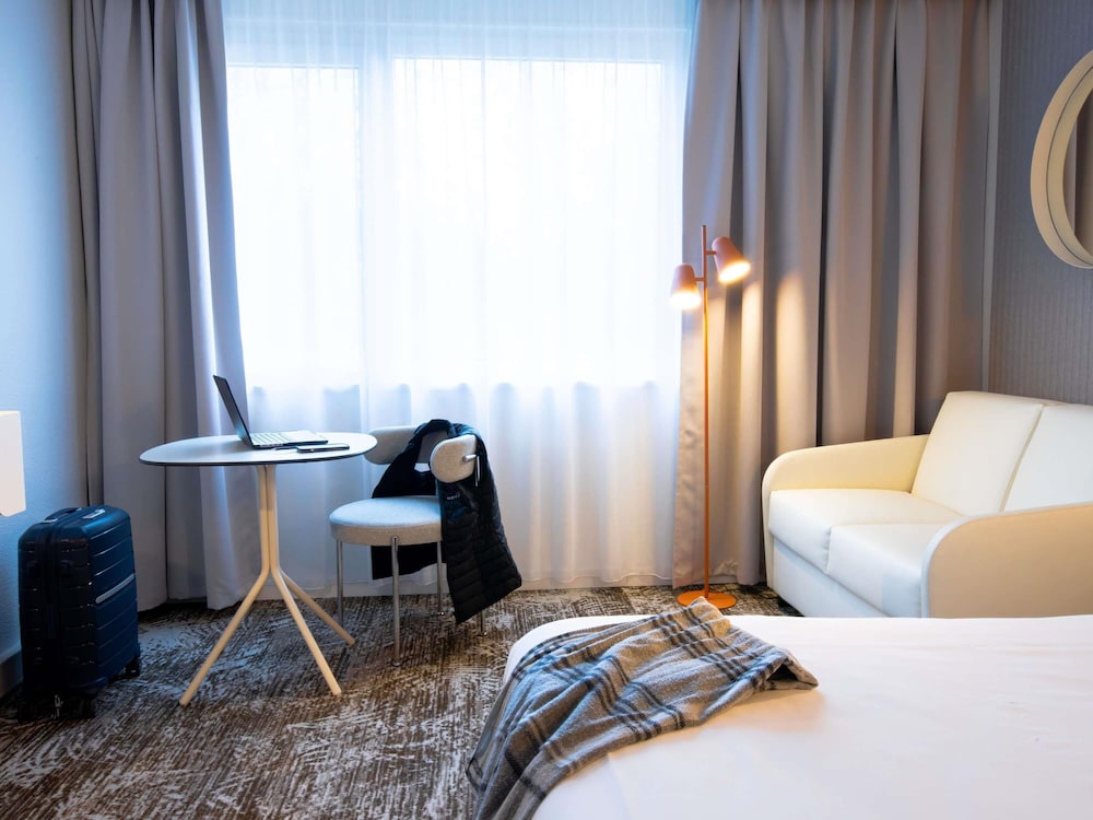 Habitación estándar con una cama doble y sofá del hotel Novotel Mulhouse Bâle Fribourg. Foto 5