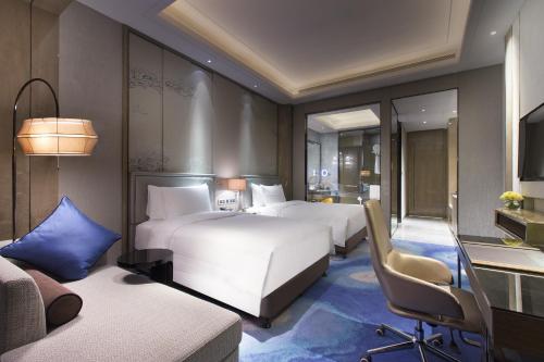 HABITACIÓN FAMILIAR PREMIUM DELUXE, Una Cama King con Una Cama Individual del hotel Pullman Yantai Center. Foto 2