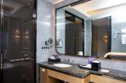 HABITACIÓN FAMILIAR PREMIUM DELUXE, Una Cama King con Una Cama Individual del hotel Pullman Yantai Center. Foto 5
