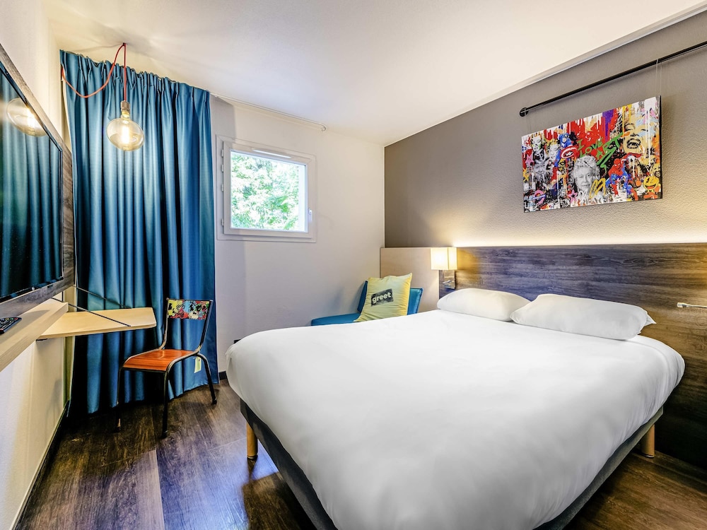 Habitación POP con cama doble y sofá del hotel Greet Bordeaux Floirac Arena