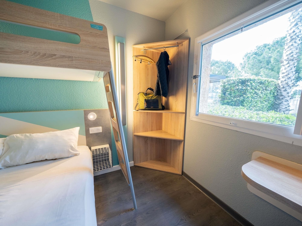 Habitación TRIPLE con una cama de gran tamaño y litera del hotel Ibis Budget Narbonne Est. Foto 12