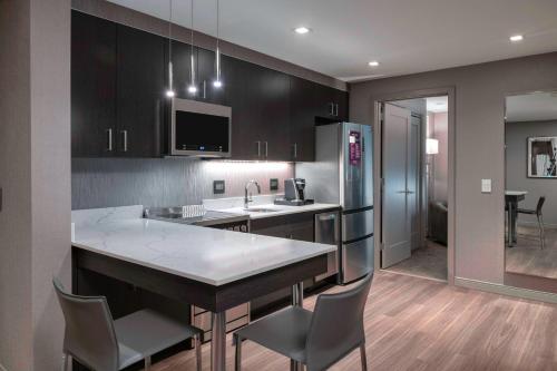 Suite más amplia con 1 dormitorio, 1 cama extragrande, sofá cama y vistas parciales a la ciudad del hotel Residence Inn Weehawken Port Imperial. Foto 4