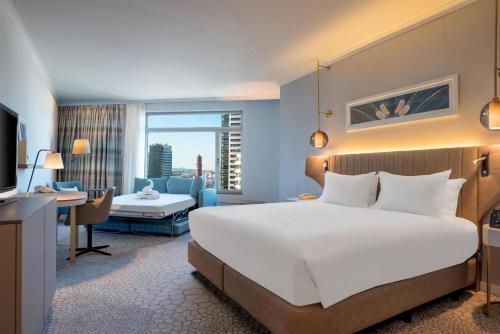 Habitación con cama extragrande y sofá cama del hotel Hilton Diagonal Mar Barcelona