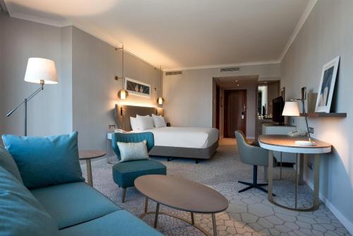 Habitación con cama extragrande y sofá cama del hotel Hilton Diagonal Mar Barcelona. Foto 1
